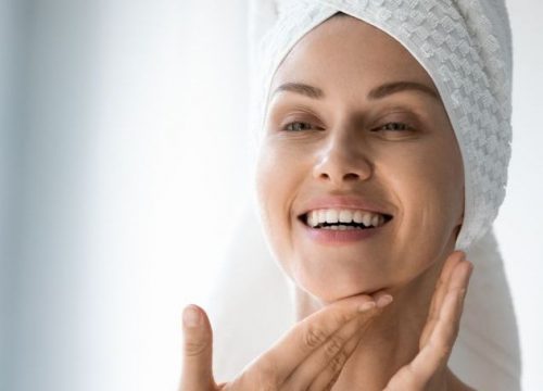 Happy woman touching her face after getting out of the shower