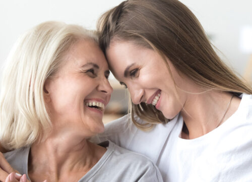 Photo of a woman smiling and hugging her mom